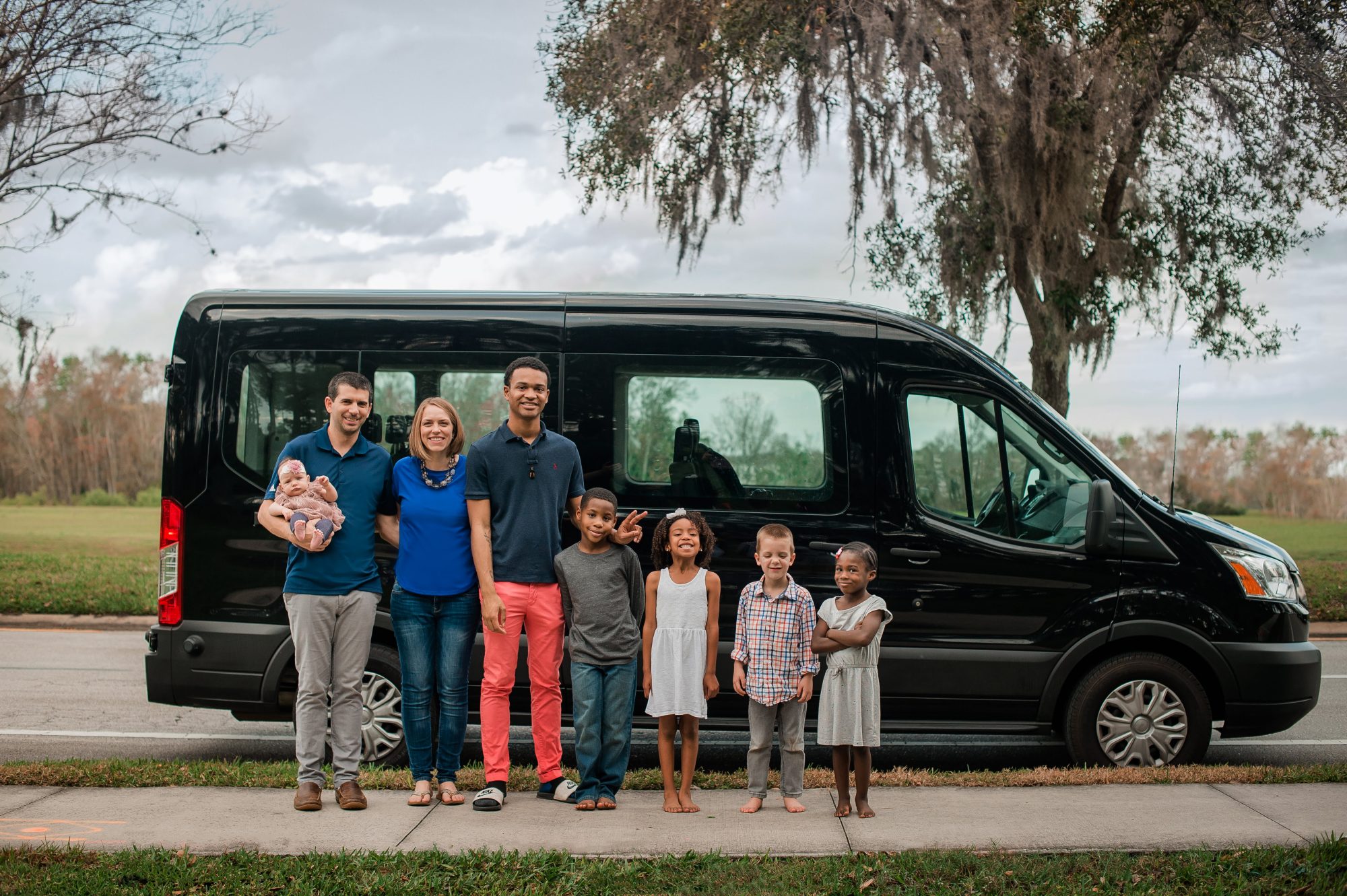 Amico family photo standing in front of van