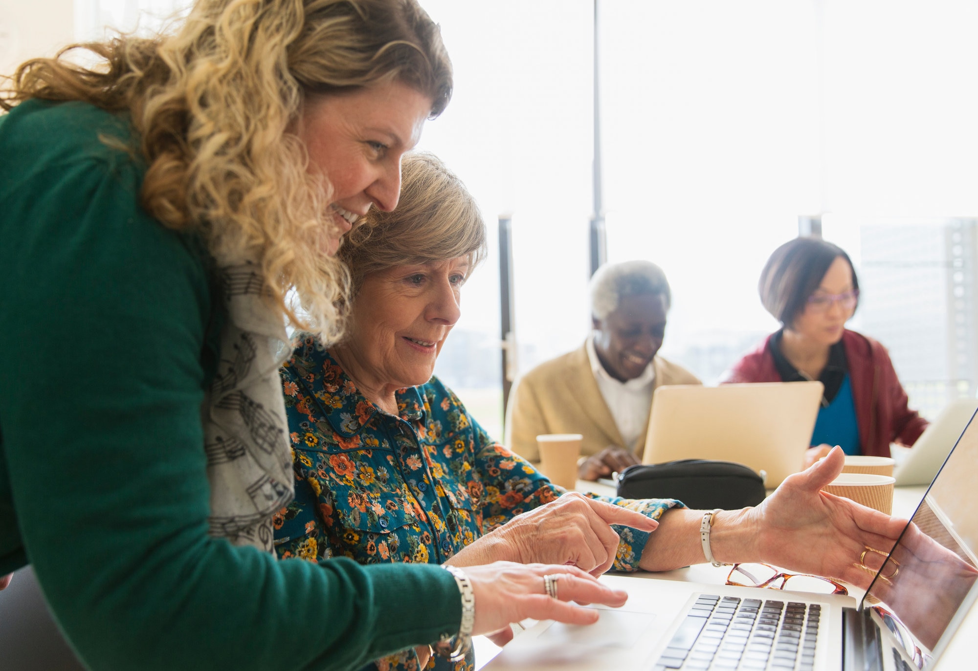 Business women using a laptop in a conference room meeting