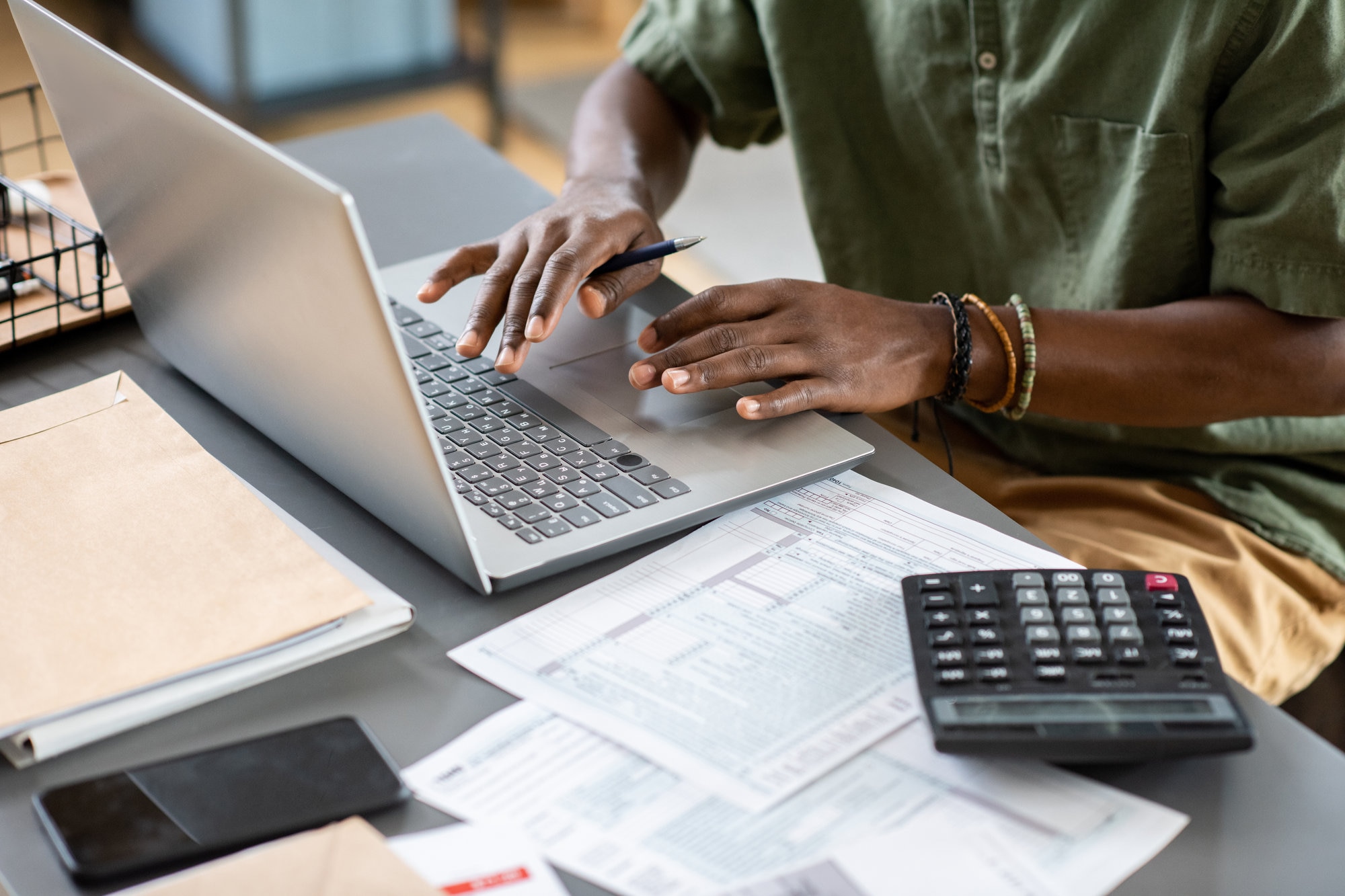 Man typing on laptop working on finances online.