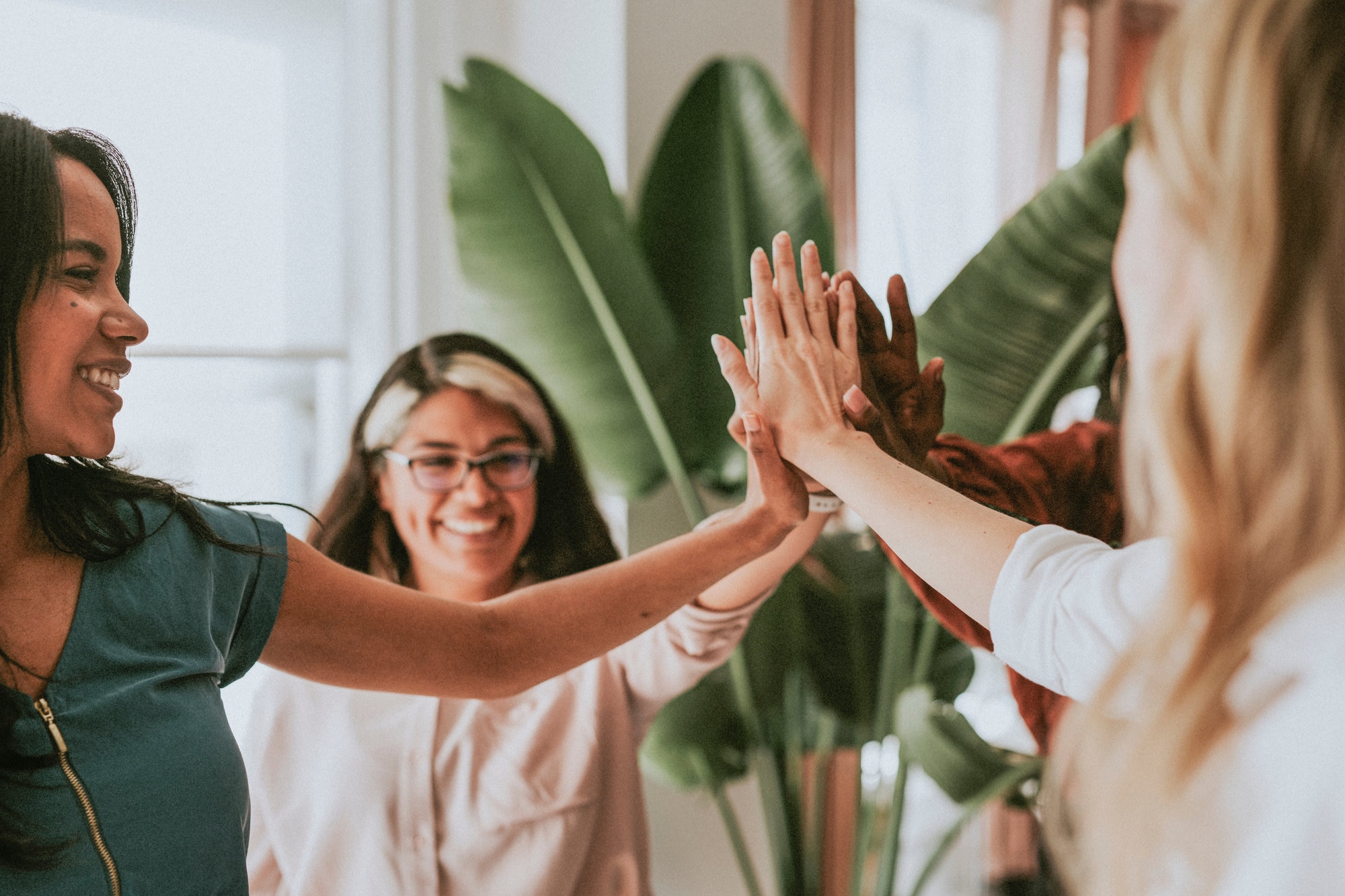 Multi-ethnic women all touching hands in center of circle
