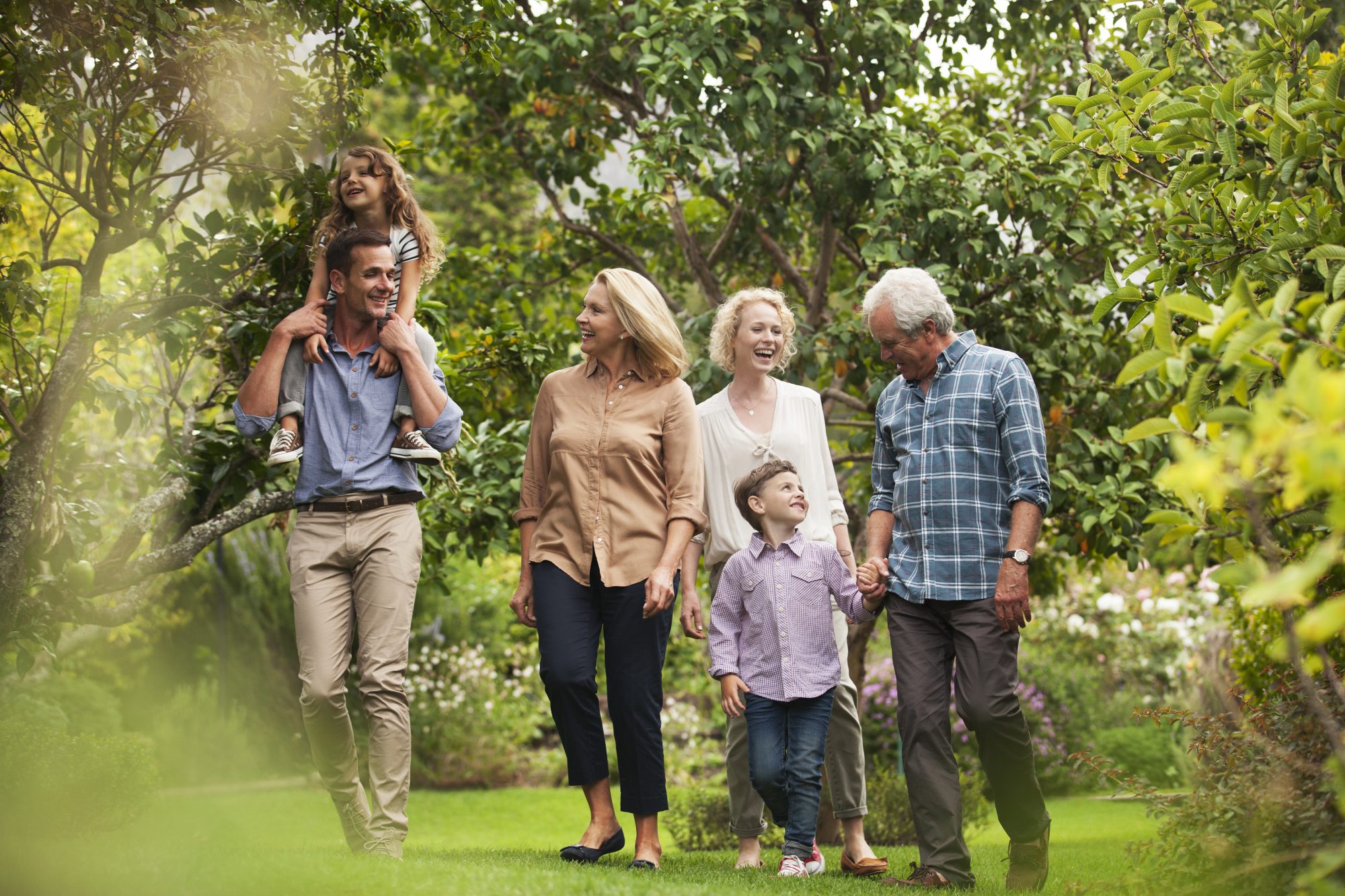 Multi-generation family walking together in park