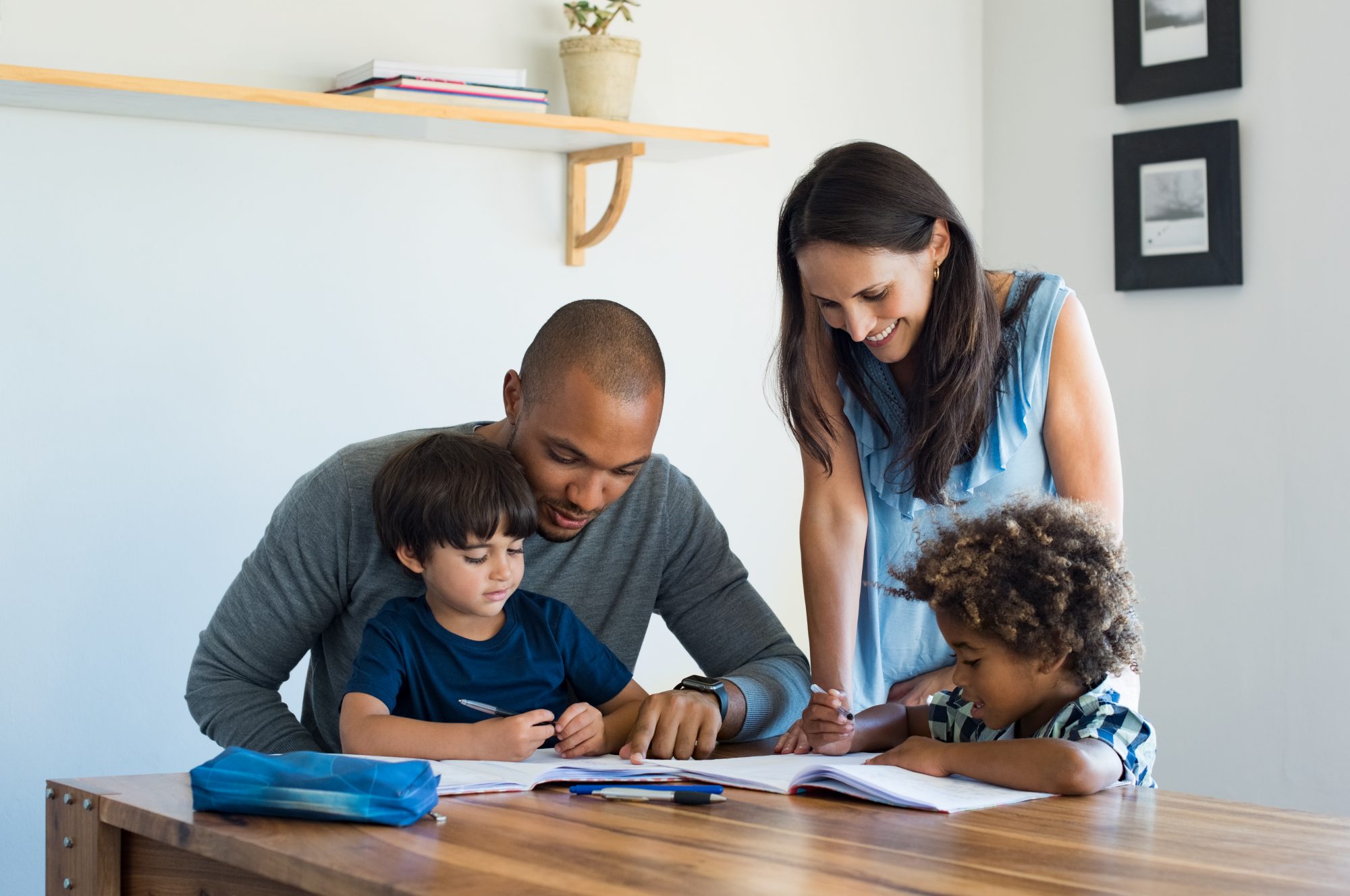 Family sitting at table doing homework together