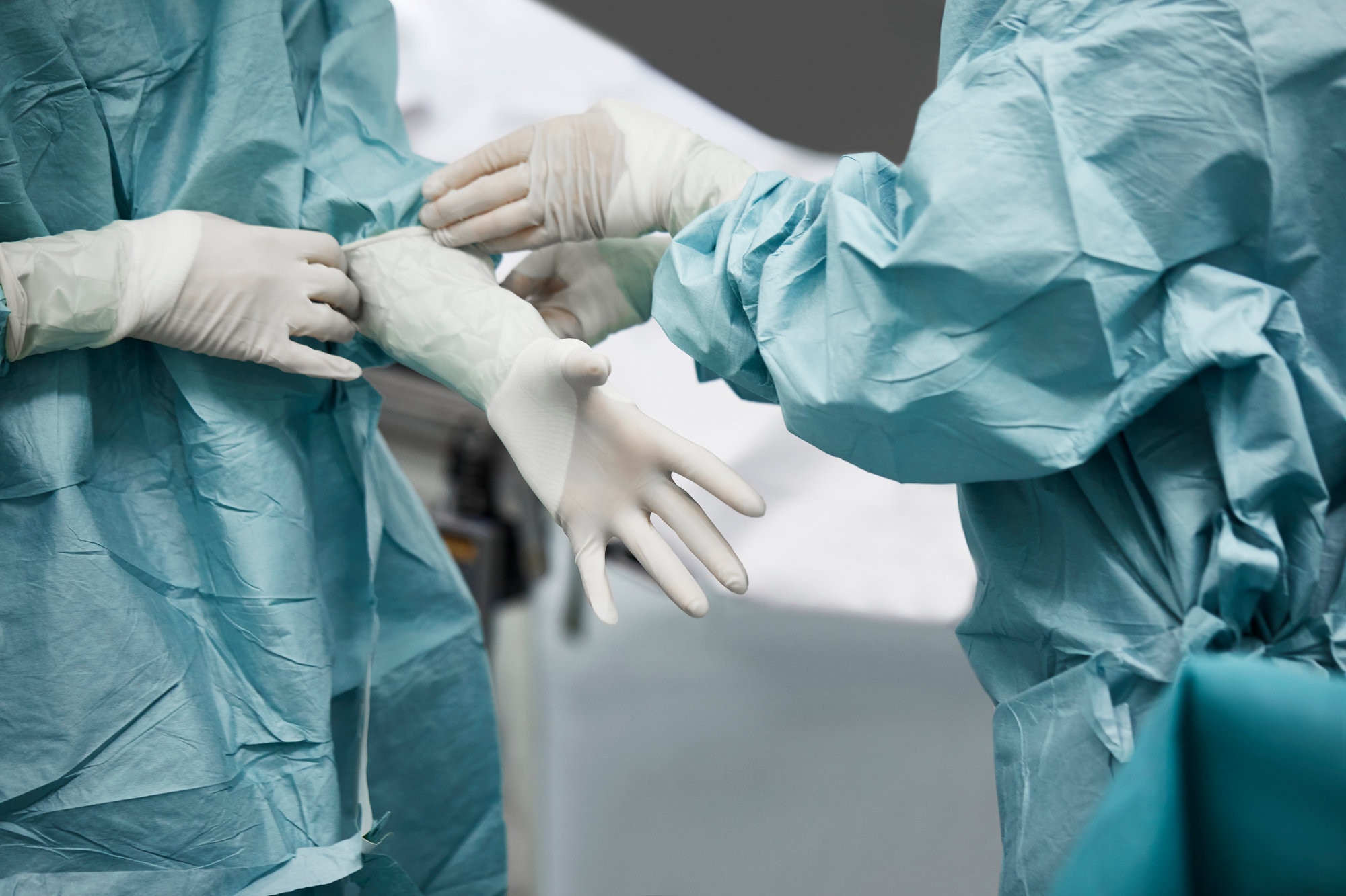 Two doctors putting on their plastic gloves