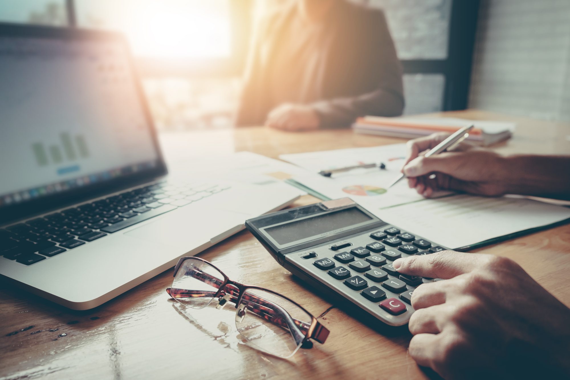 A man goes over the numbers with his computer and calculator. Because of tax reform, it is important to look at all of your tax planning options.