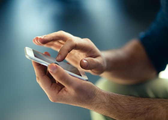 Hands holding and touching a mobile device
