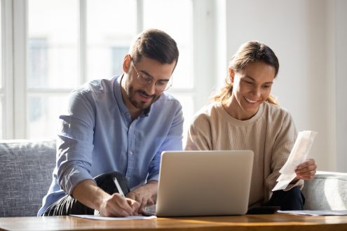 Happy couple using laptop