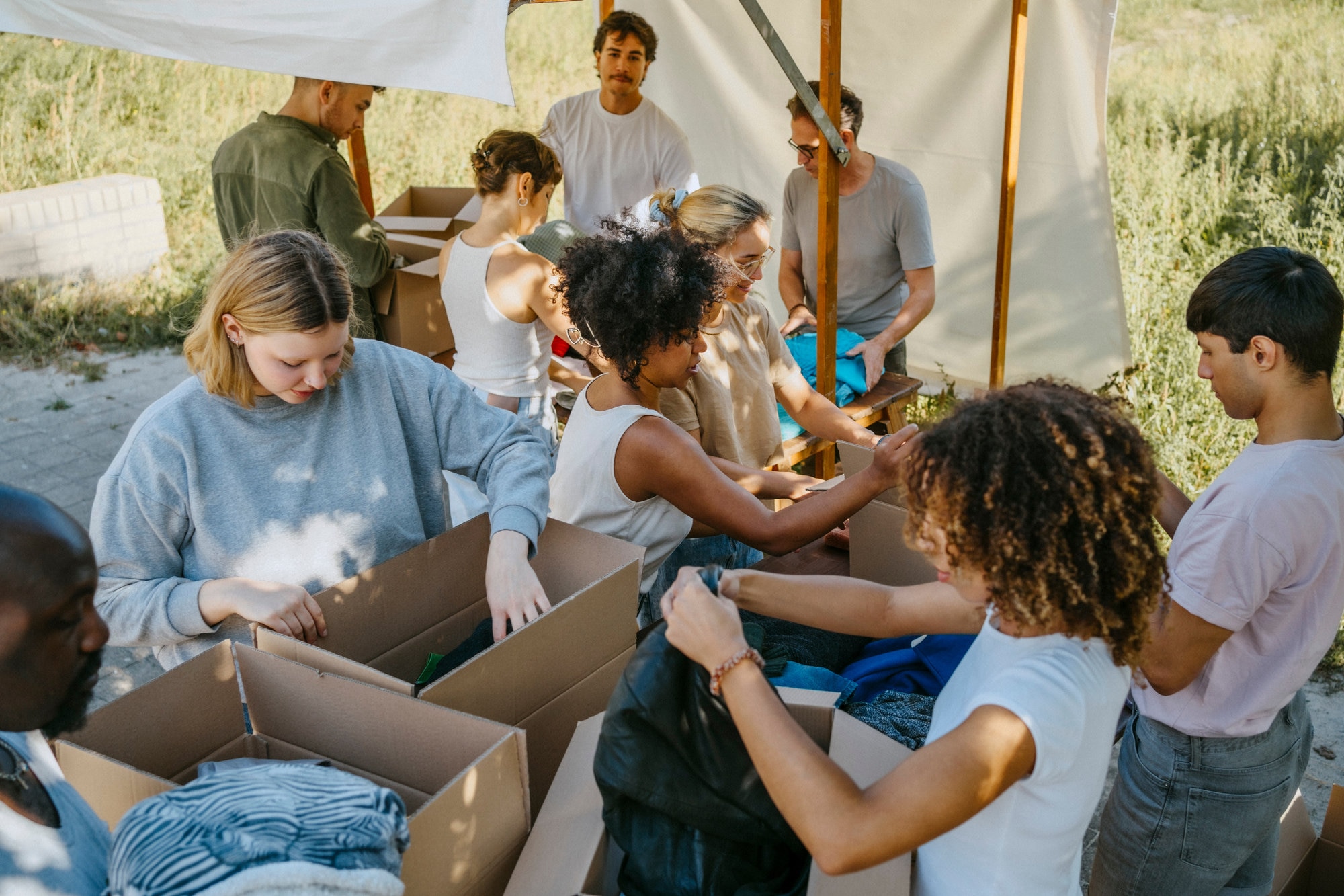 Volunteers sorting clothes from cardboard boxes during a community charity drive