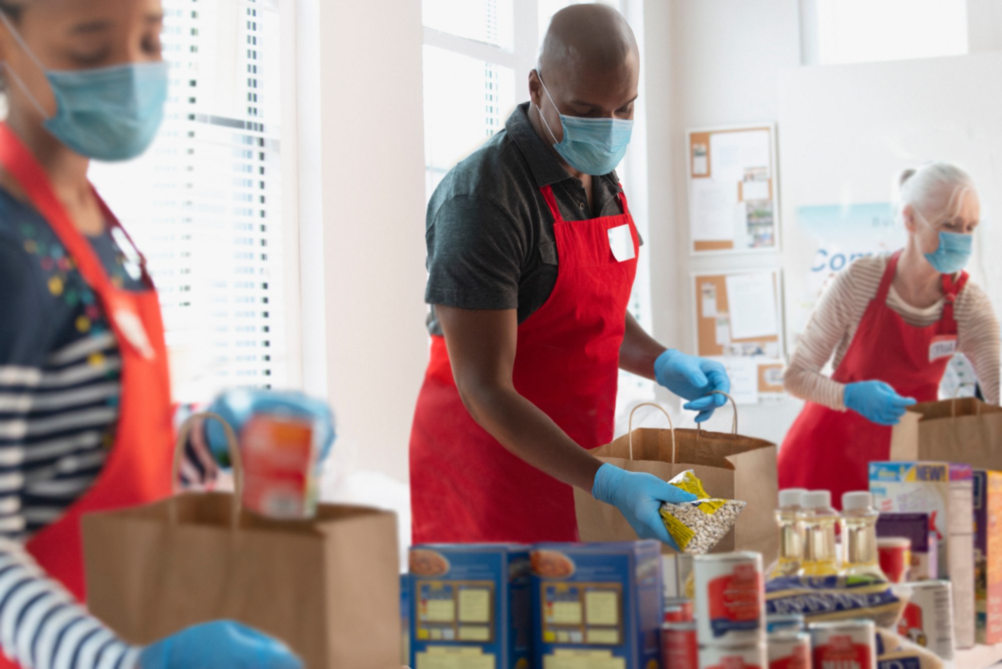 People working together packing food in paper bags