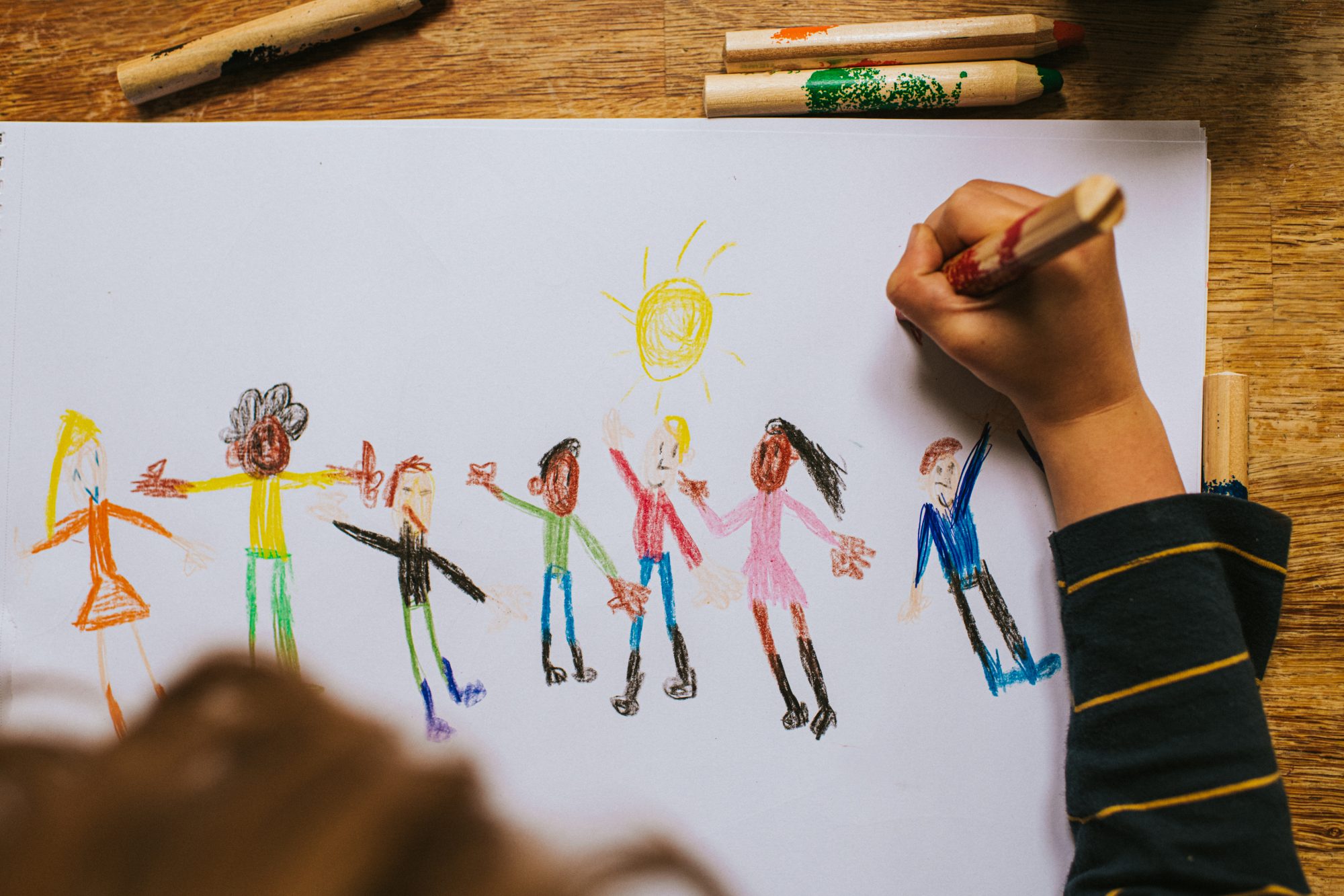 A child's colorful drawing of diverse people holding hands