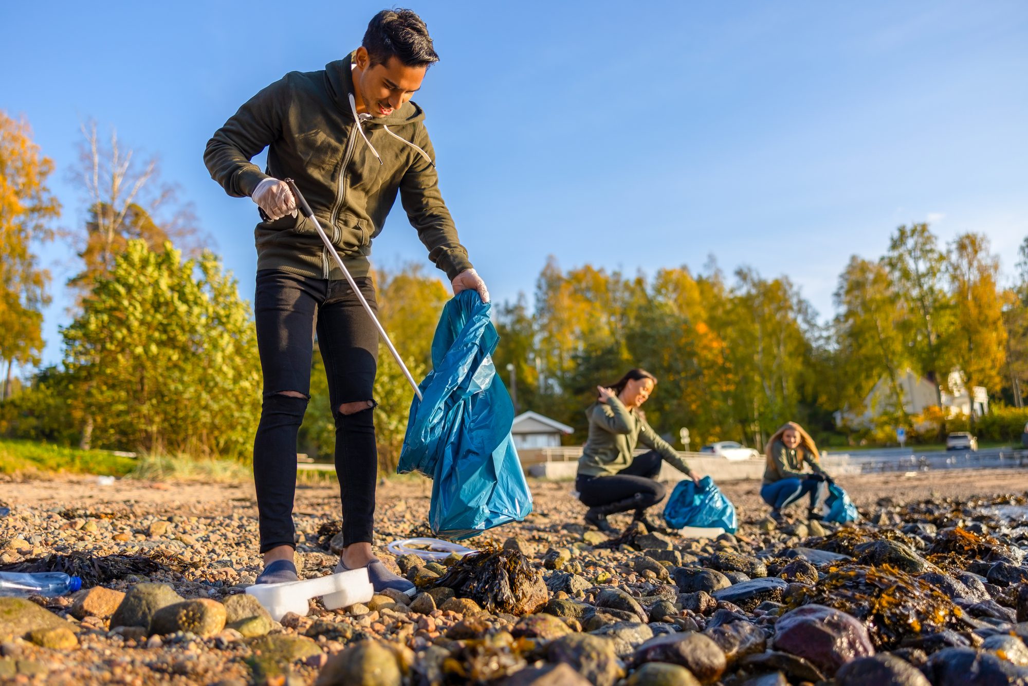 Volunteer cleaning up trash in a field