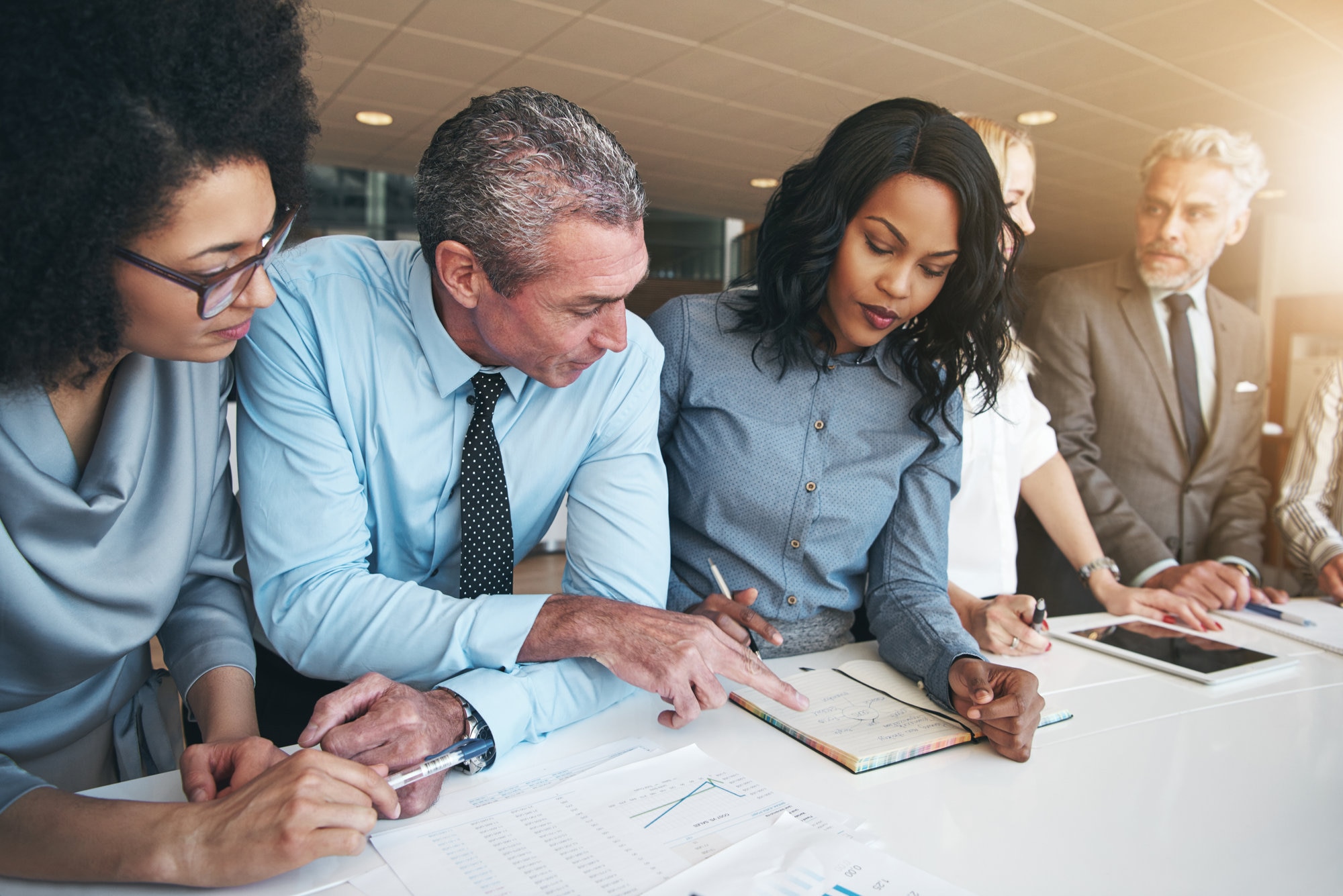 Workers discussing papers sitting in office
