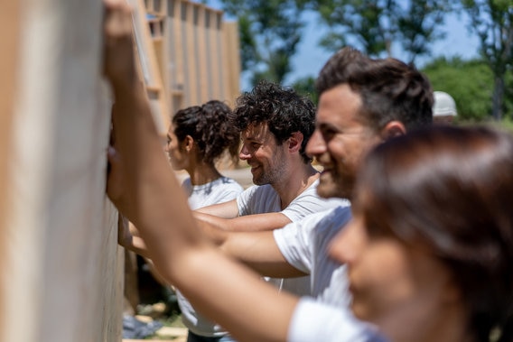 Volunteers holding a house frame