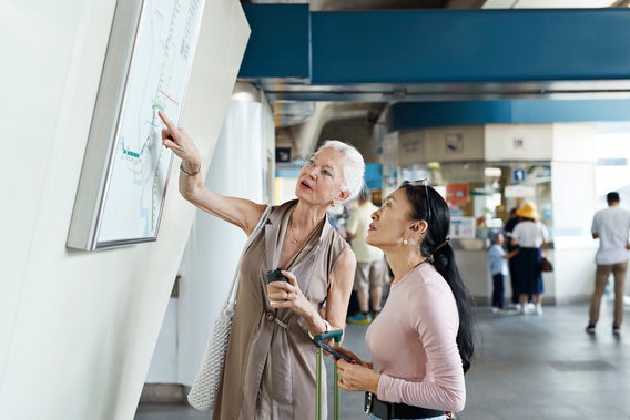 Women pointing at map in coffee shop