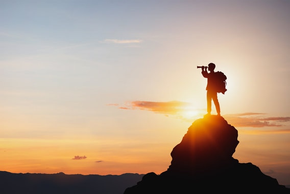 Silhouette of man holding binoculars