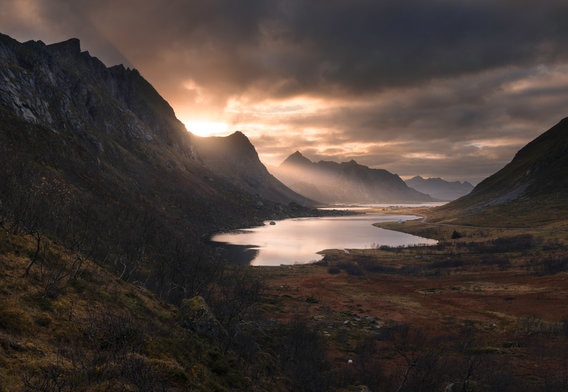 view across a scottish loch and mountains with sunlight coming through clouds
