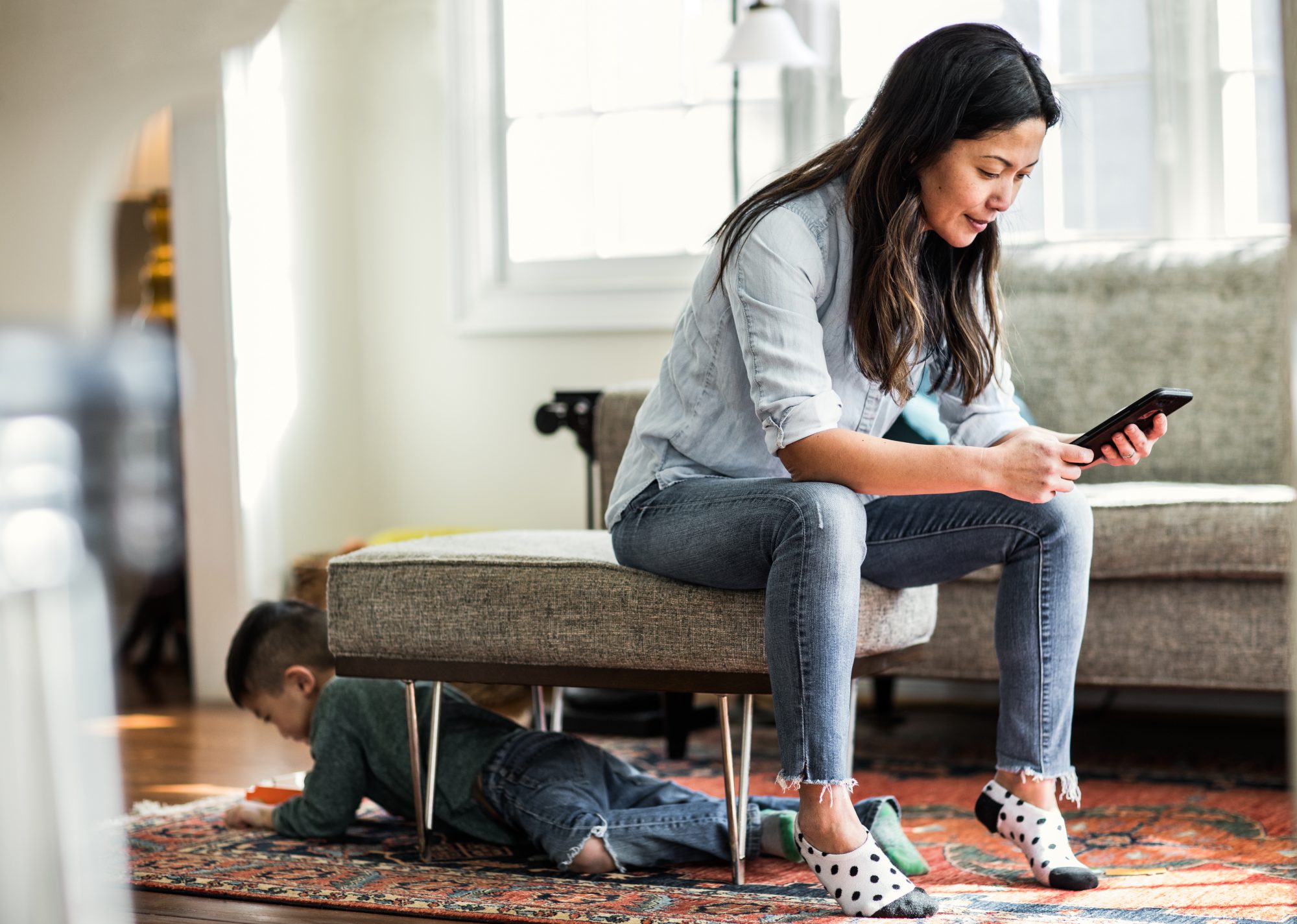 Woman sitting on the couch looking at her smart phone