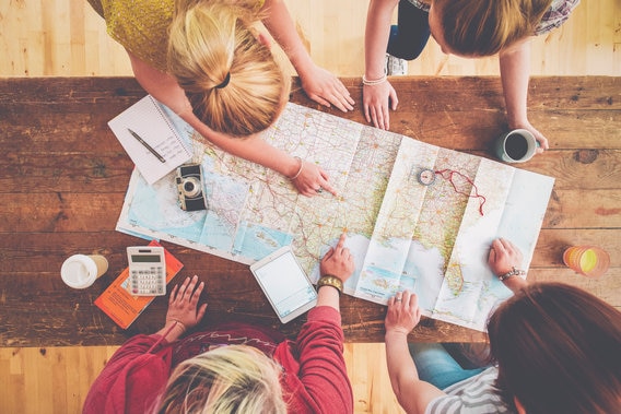 looking from above at people pointing to a map on a table