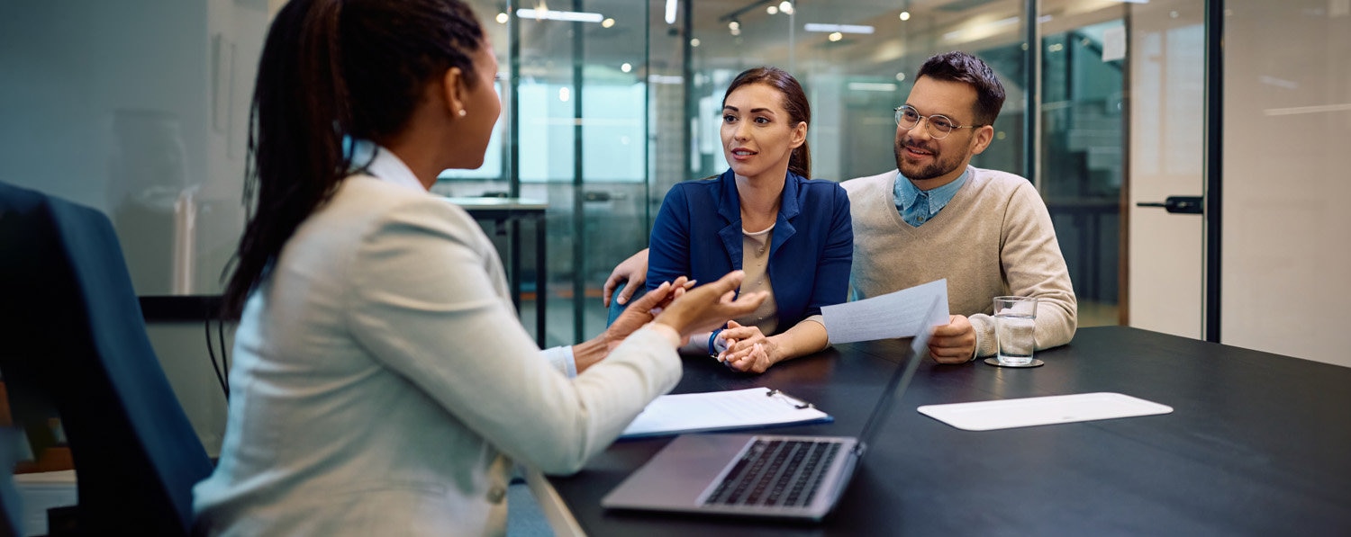 Young couple discussing donating stock with financial advisor