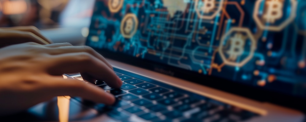 Person typing on laptop with Bitcoin icon 