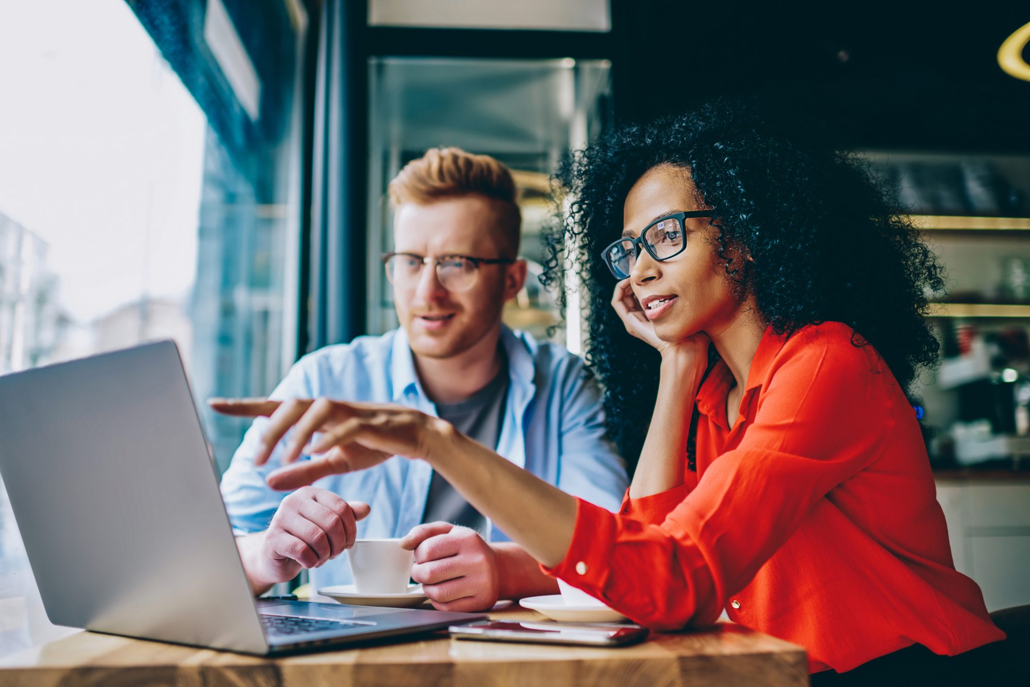 Two multicultureal coworkers working together on a laptop