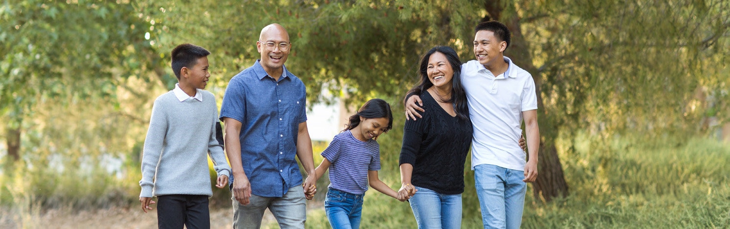 Happy asian family walking and talking in nature.