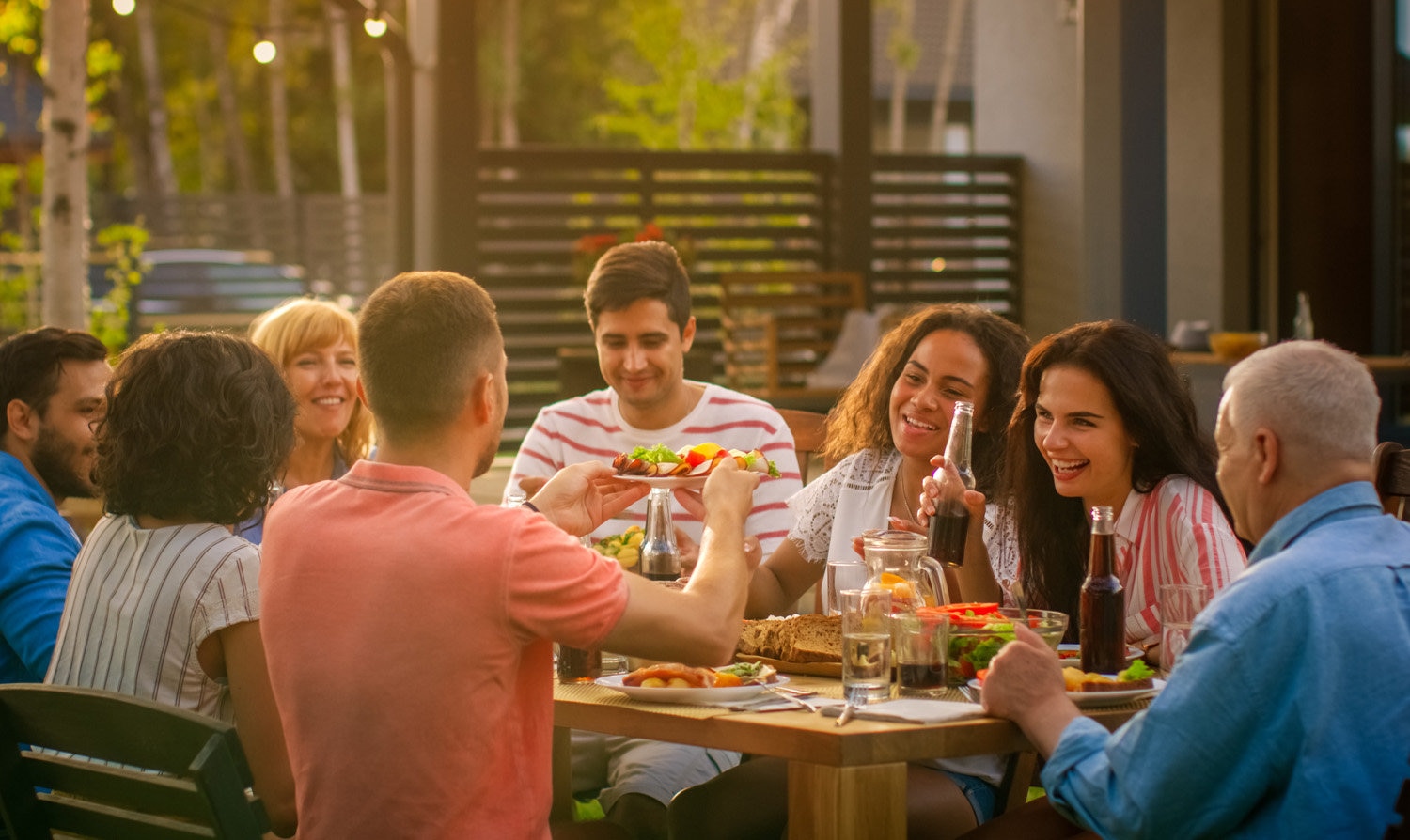 A family eating outdoors and discussing family giving traditions.